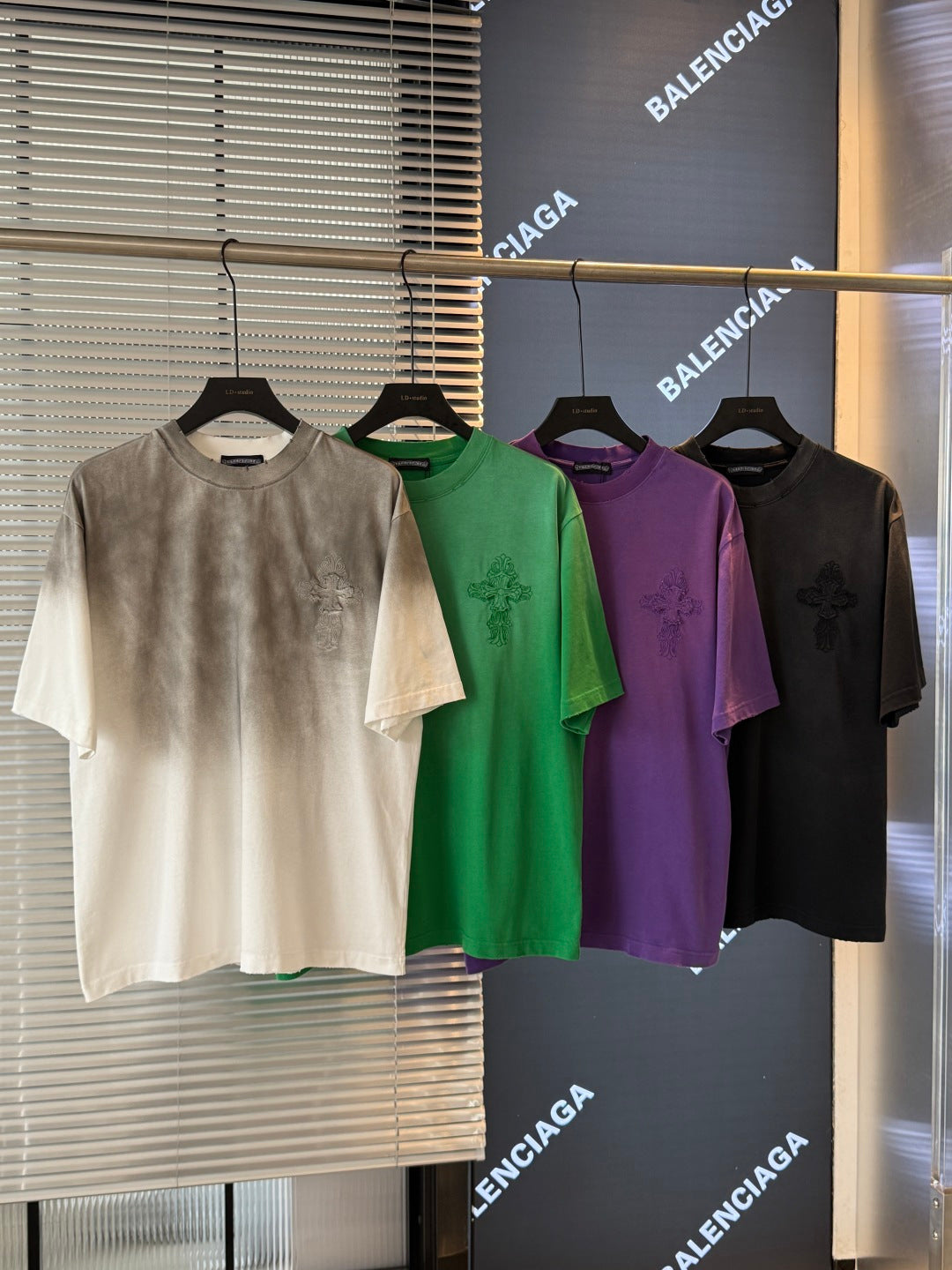 Short-sleeve T-shirts: off-white, green, purple, and black with small chest graphic