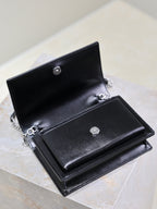 YSL black leather bag open with dual compartments, snap buttons and chain hardware