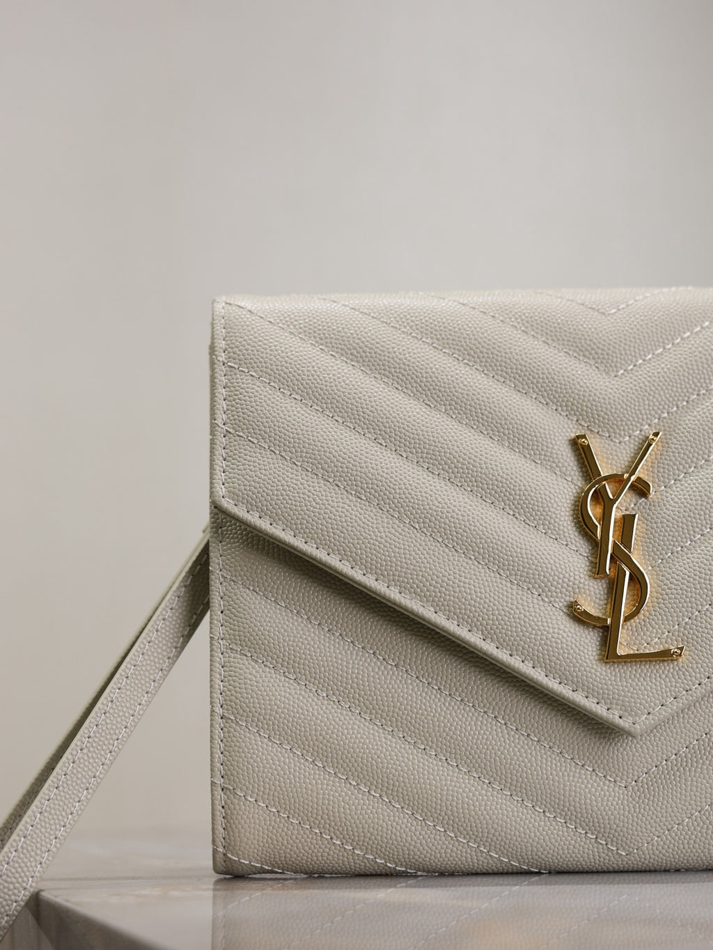 YSL quilted front flap bag in white with gold YSL logo and chevron stitching