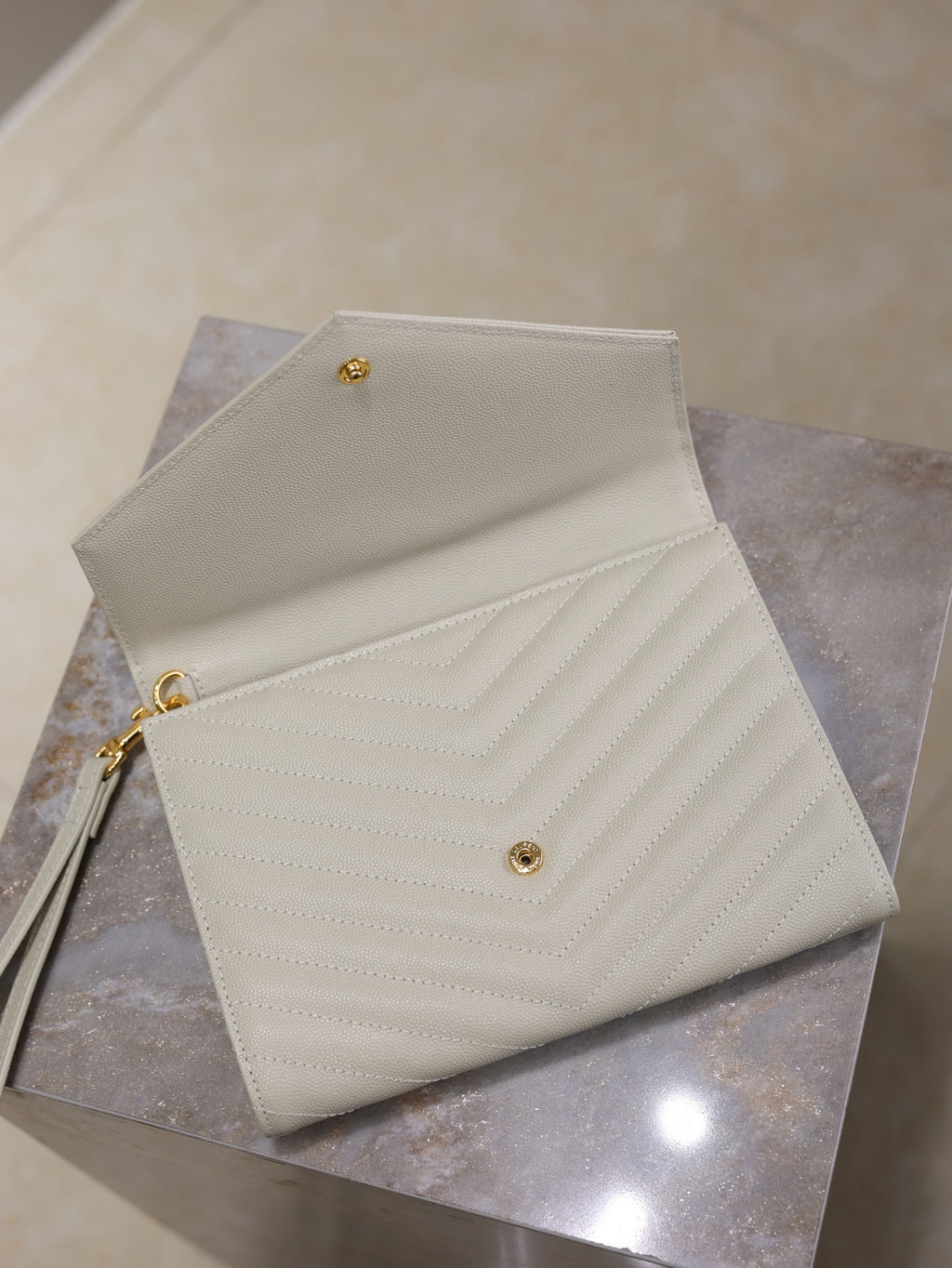 Women’s YSL small shoulder bag open flap view, white quilted chevron, gold hardware