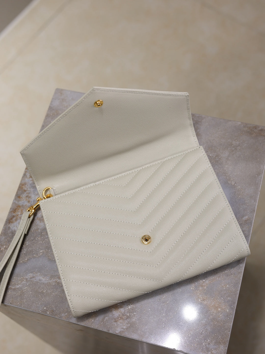 Women’s YSL small shoulder bag open flap view, white quilted chevron, gold hardware