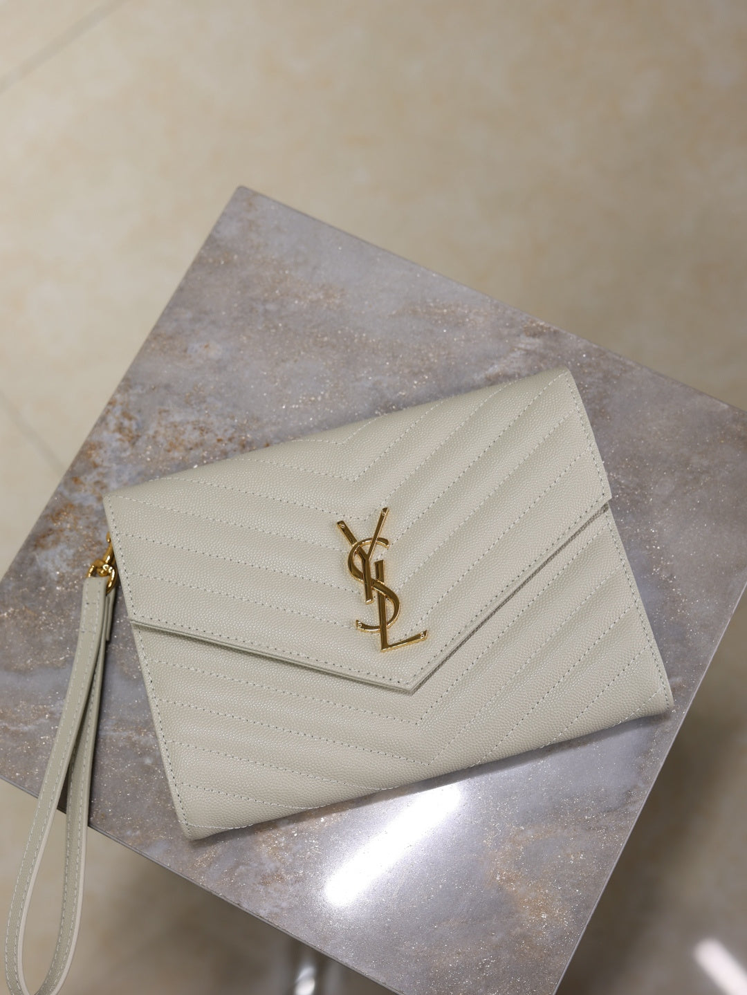 YSL small white quilted shoulder bag with gold YSL logo, angled front view