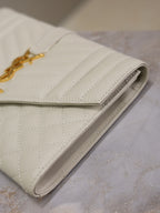 Small quilted fold-over clutch, light white leather with side seam detail.