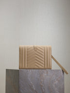 Women’s YSL small bag back view in light beige quilted leather with adjustable strap