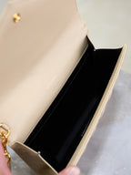 Women’s YSL small bag open view with light beige exterior and black interior lining