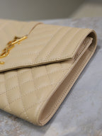 Women’s YSL small bag detail: light beige quilted leather with gold-tone chain strap