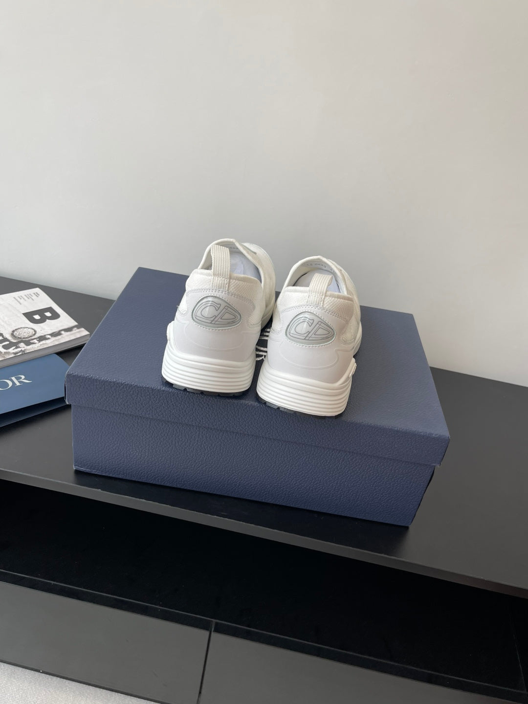Back view of white Dior low-top sneakers with rear logo detailing