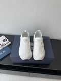 White Dior low-top sneakers on display, textured upper and cushioned sole