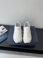 White Dior low-top sneakers on display, textured upper and cushioned sole