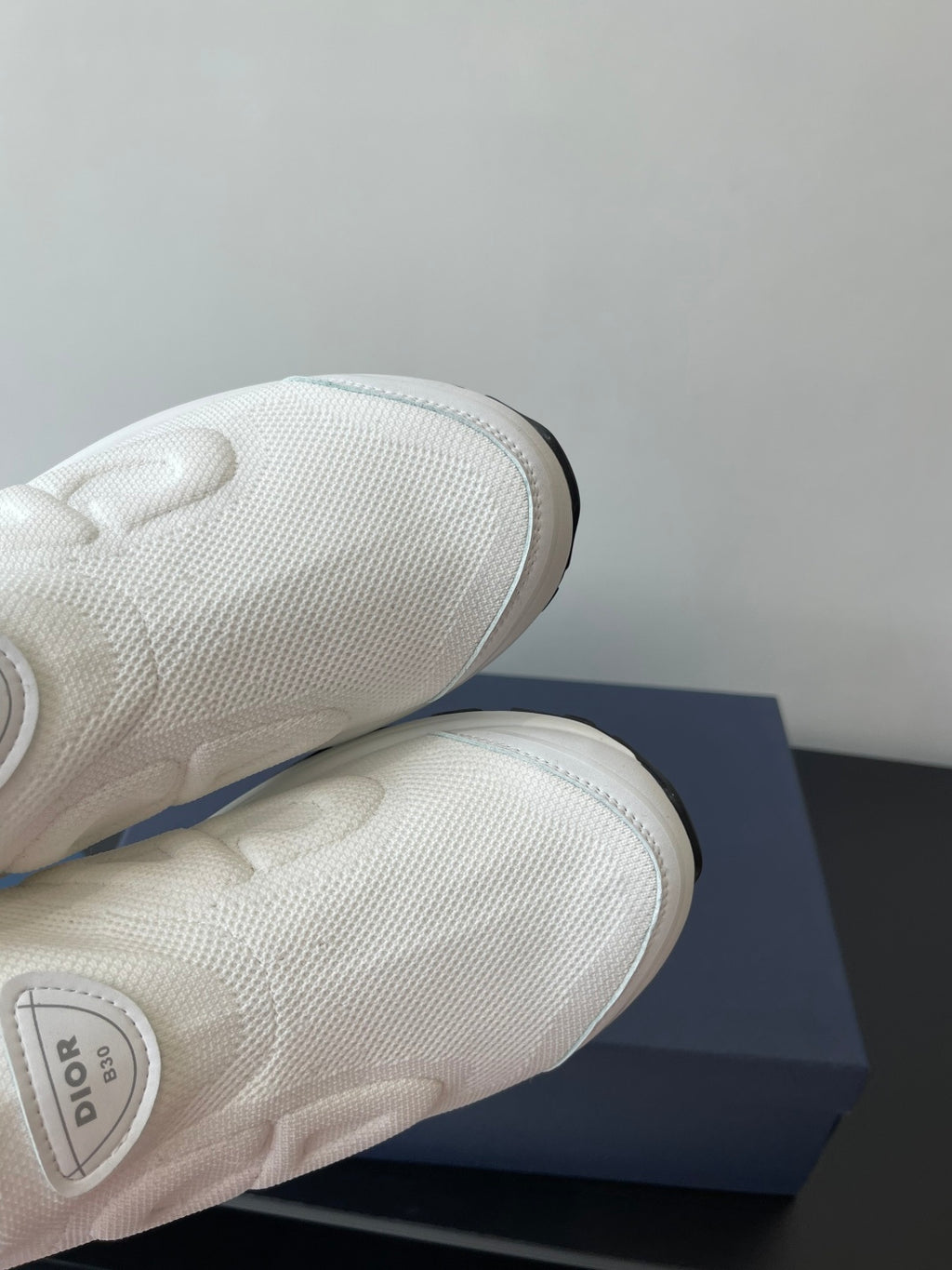 White Dior sneakers outsole and toe detail, textured knit upper and stitched sole