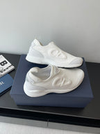 Pair of white Dior slip-on sneakers with wavy side logo and cushioned sole