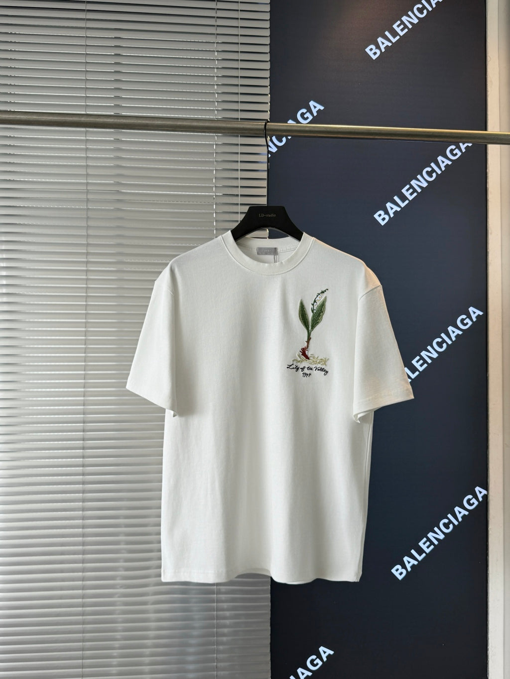 White short-sleeve T-shirt on hanger with chest botanical bird embroidery
