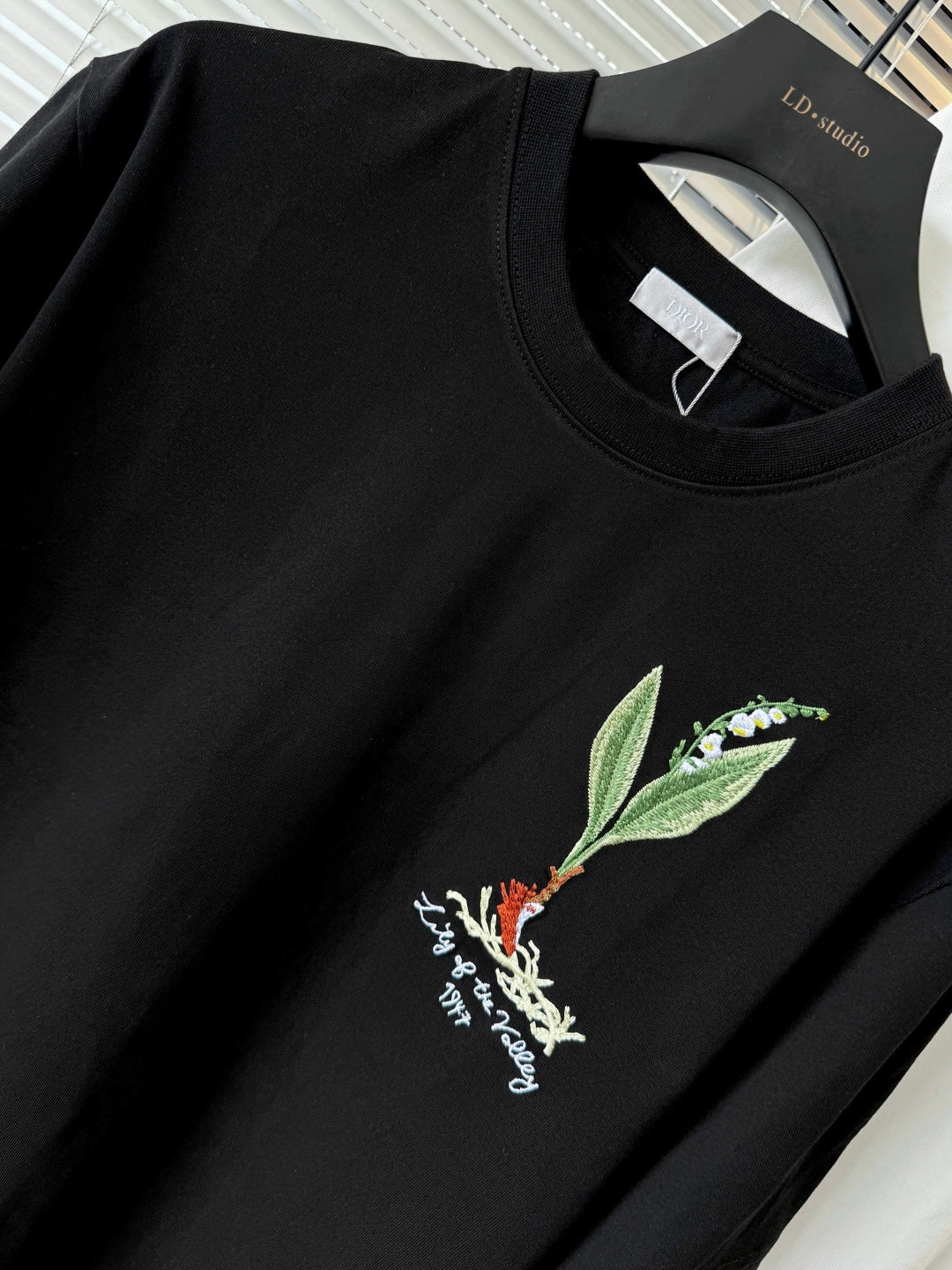 Black short-sleeve T-shirt close-up with green leaf and bird chest embroidery