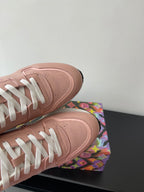 Women's Louis Vuitton sneakers, blush pink leather toe with white lace eyelets.