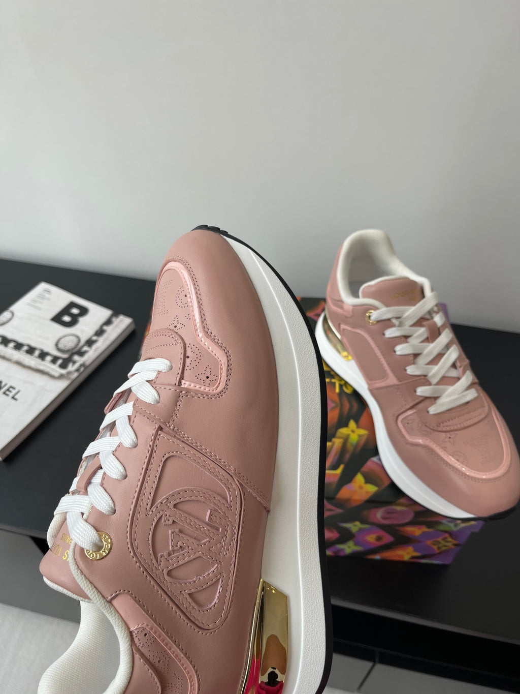 Women's Louis Vuitton sneakers, blush pink side panel with embossed logo and white laces.