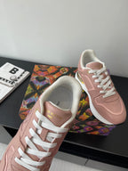 Women's Louis Vuitton sneakers, blush pink with white laces and gold-trim heel detail.