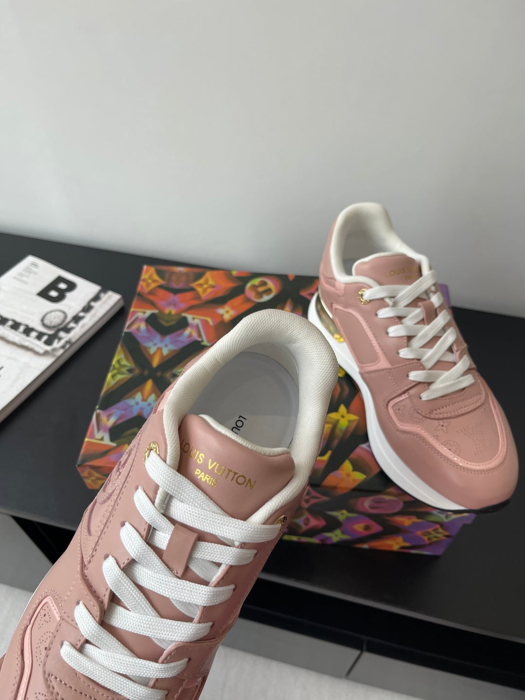 Women's Louis Vuitton sneakers, blush pink with white laces and gold-trim heel detail.