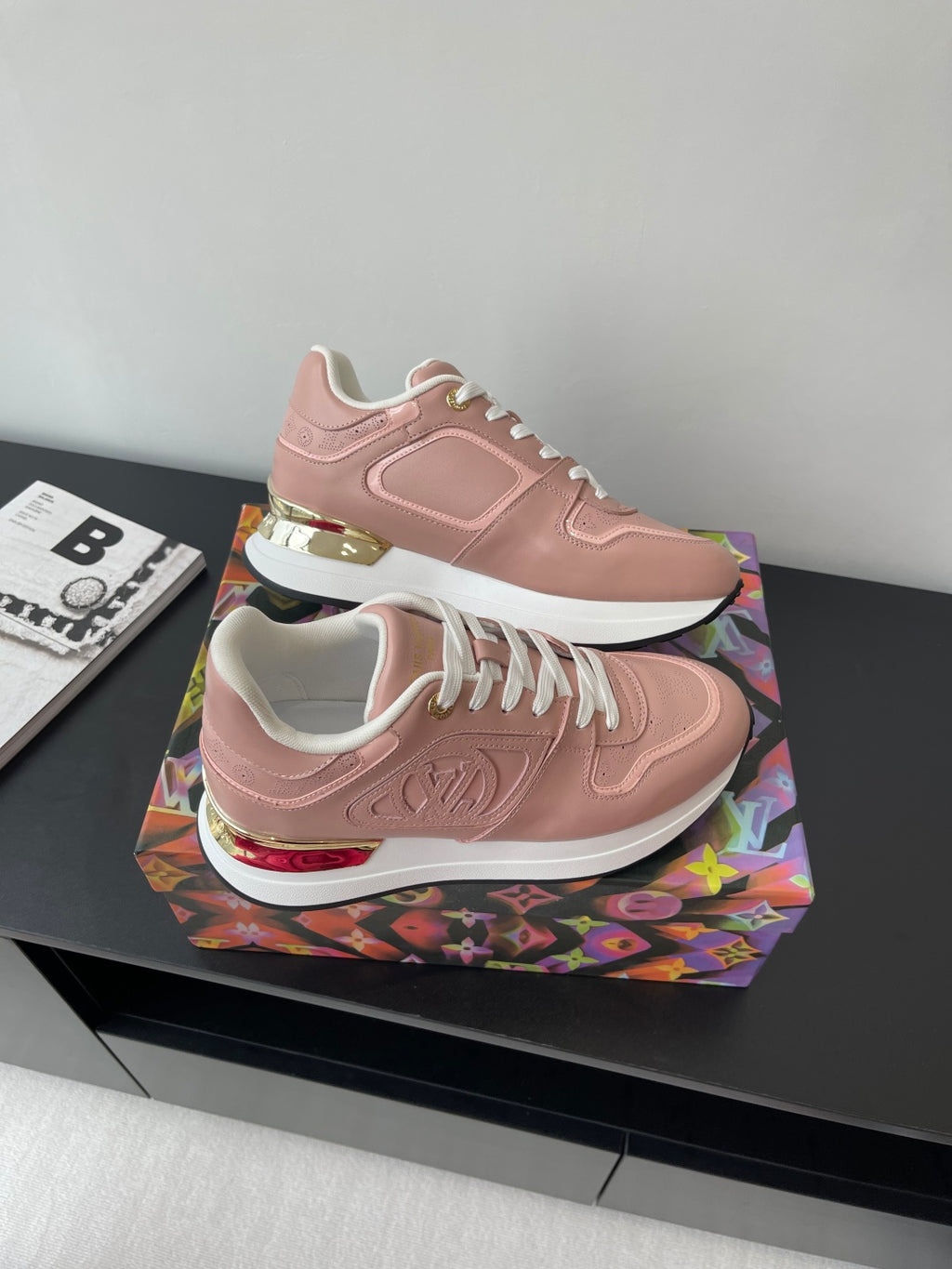 Women's Louis Vuitton sneakers, blush pink with white laces, gold heel detail, and logo emboss.