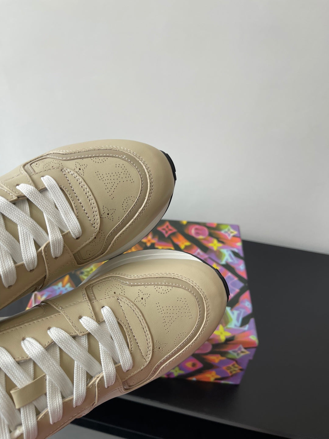 Louis Vuitton ladies sneakers, light beige upper with white laces and visible stitching.
