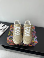 Louis Vuitton ladies low-top sneakers, light beige with white laces and stitched logo.