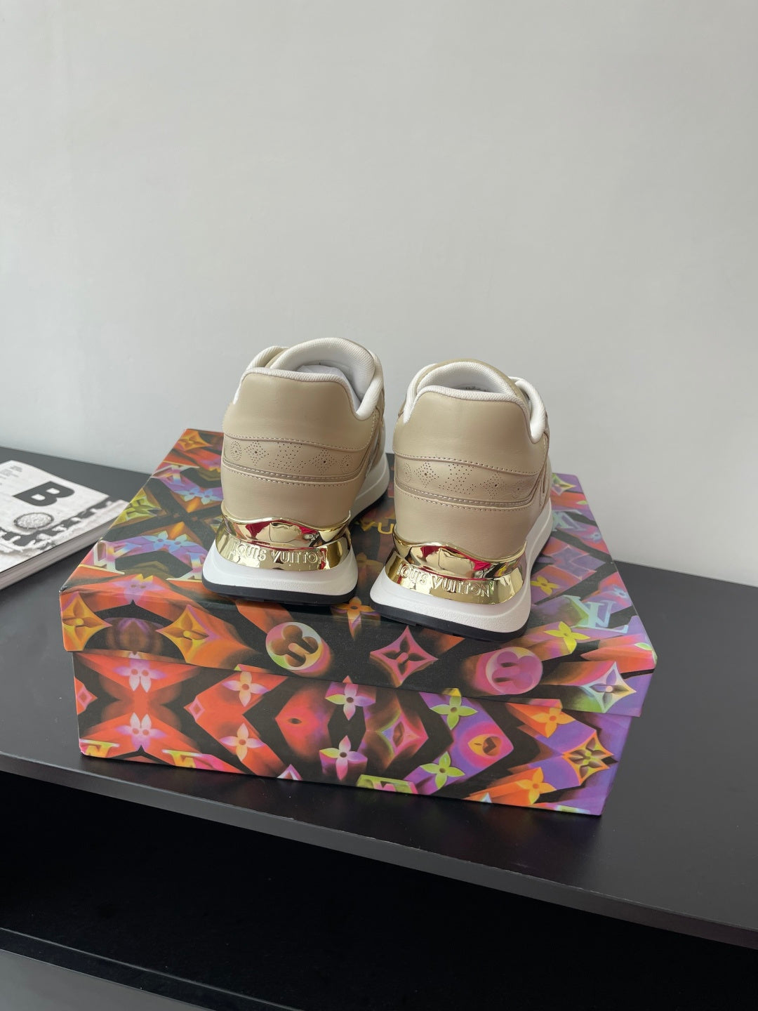 Louis Vuitton ladies sneakers, light beige with white laces, rear heel branding detail.
