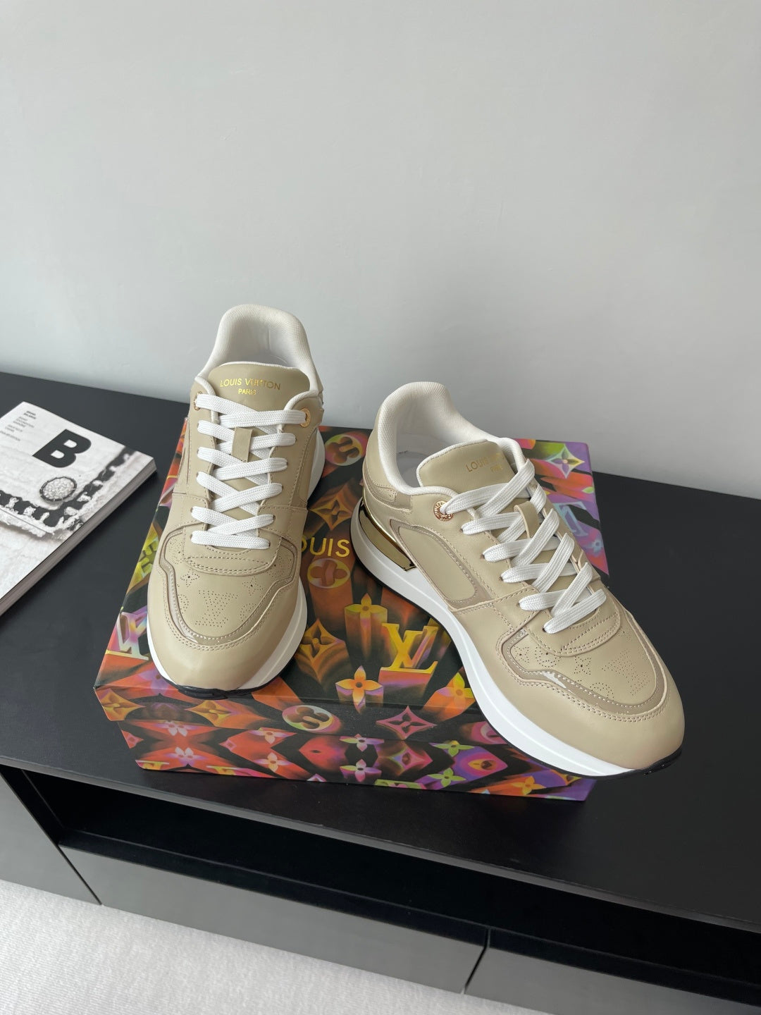 Louis Vuitton ladies low-top sneakers in light beige with white laces, side logo detail.