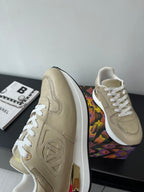 Louis Vuitton ladies sneaker side profile, light beige upper with white laces and logo emboss.