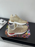 Louis Vuitton ladies low-top sneakers, light beige with white laces and red heel trim.