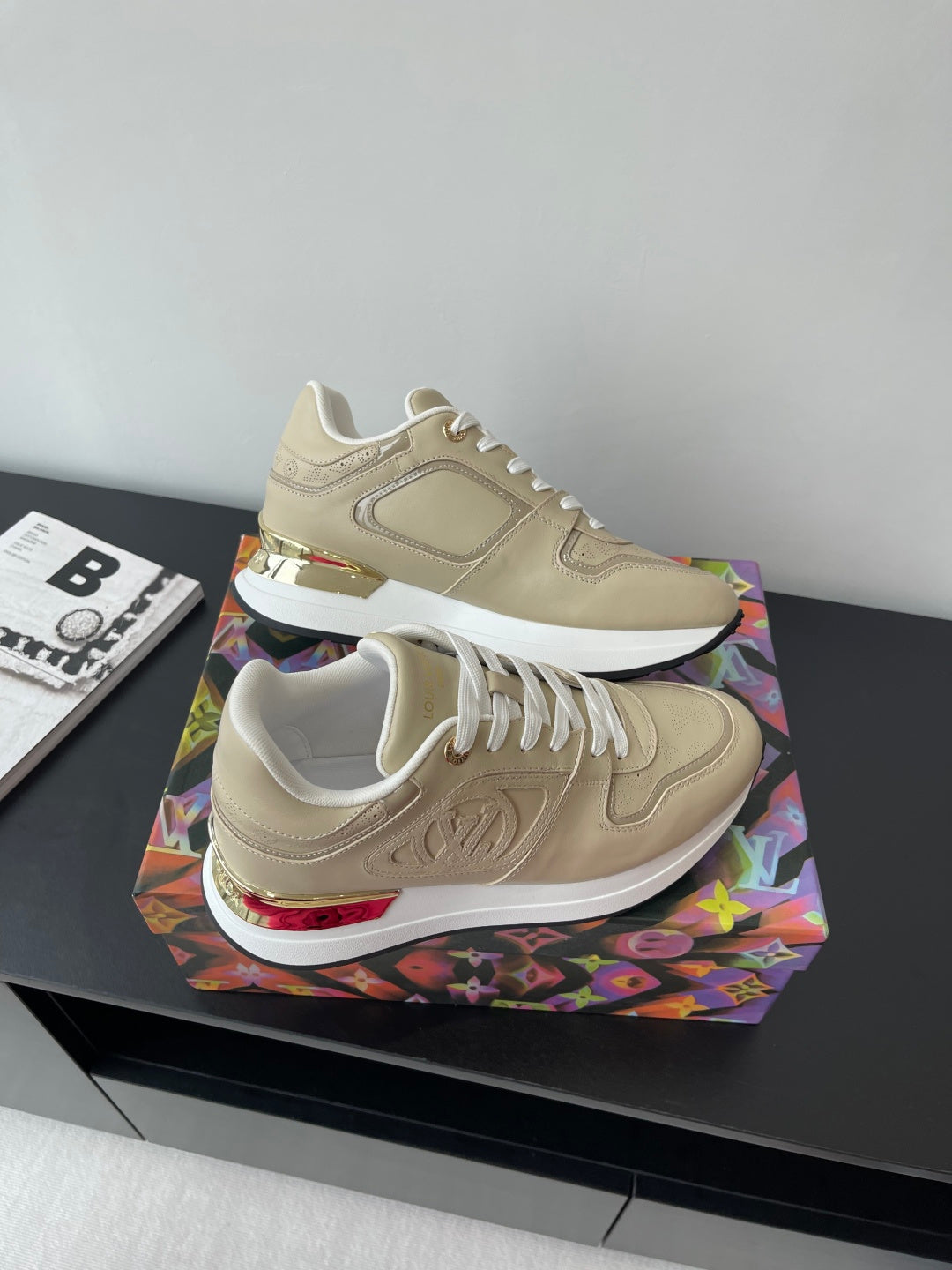 Louis Vuitton ladies low-top sneakers, light beige with white laces and red heel trim.