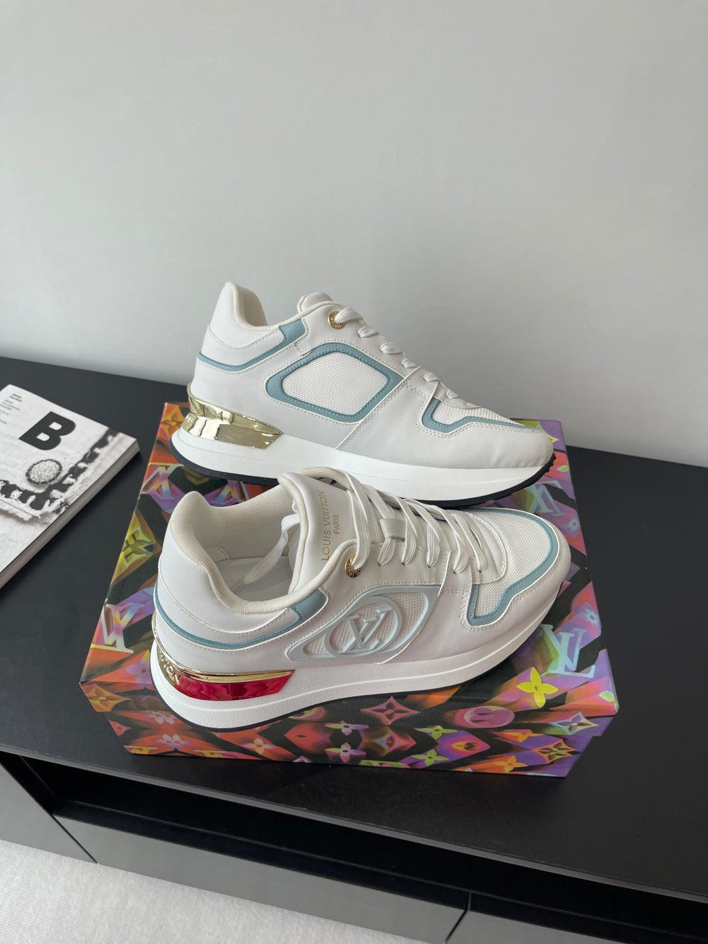 White and light blue lace-up sneakers with embossed texture and gold heel accents