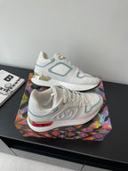 White and light blue lace-up sneakers with embossed texture and gold heel accents