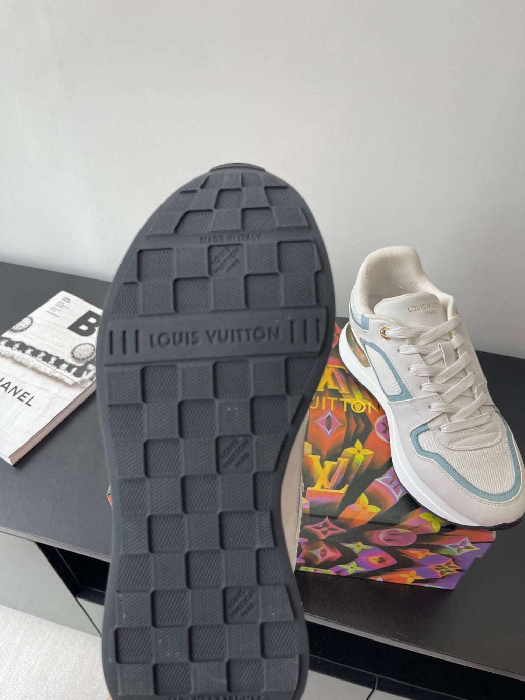 Shoe outsole view: dark tread sole with white and light blue upper