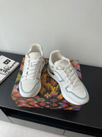 White and light blue lace-up sneakers pair with matching trim and gold heel accents