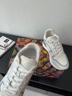 White and light blue lace-up sneakers shown from the toe and tongue