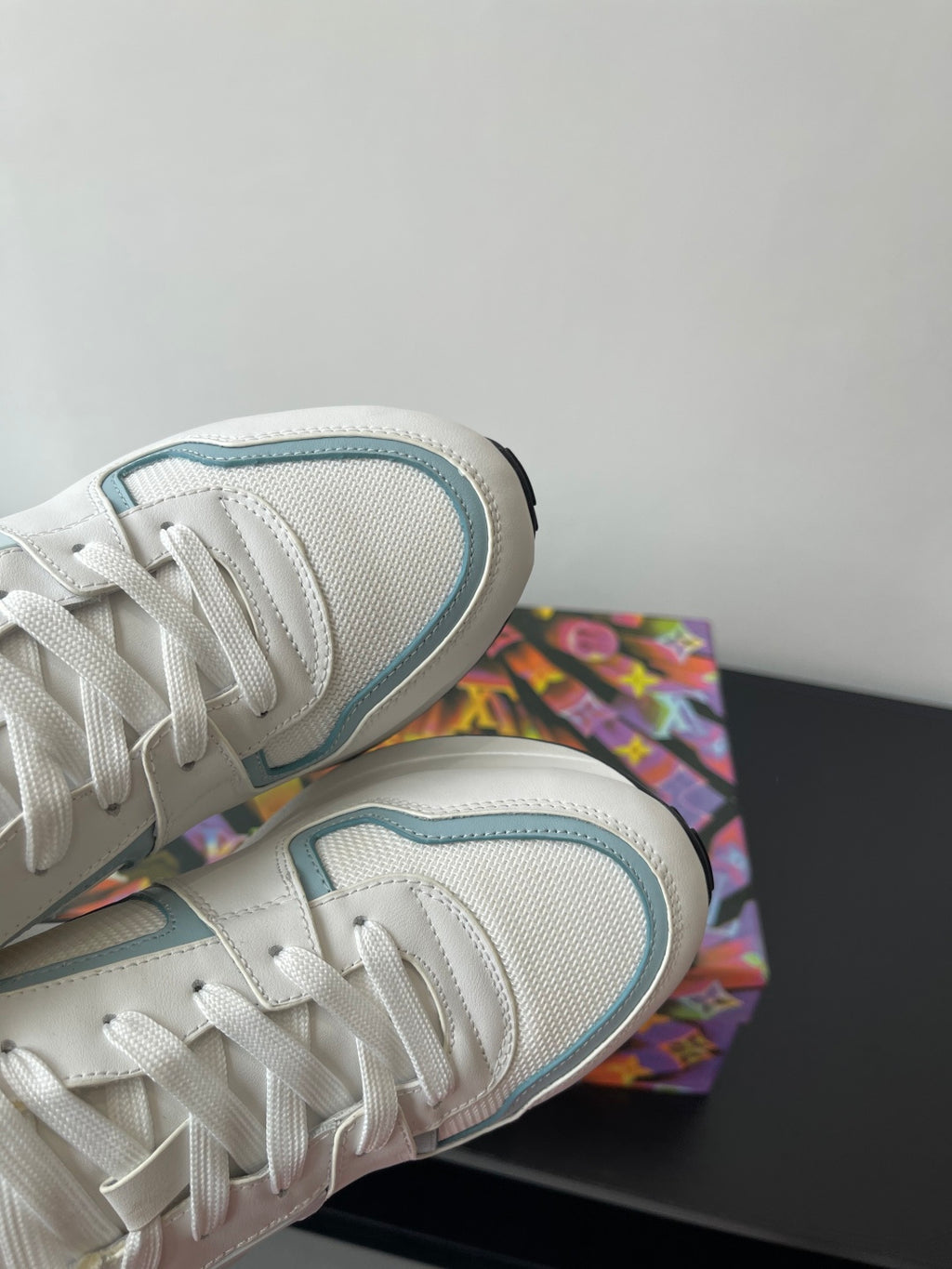 Close-up of white and light blue sneaker side mesh and lace-up area