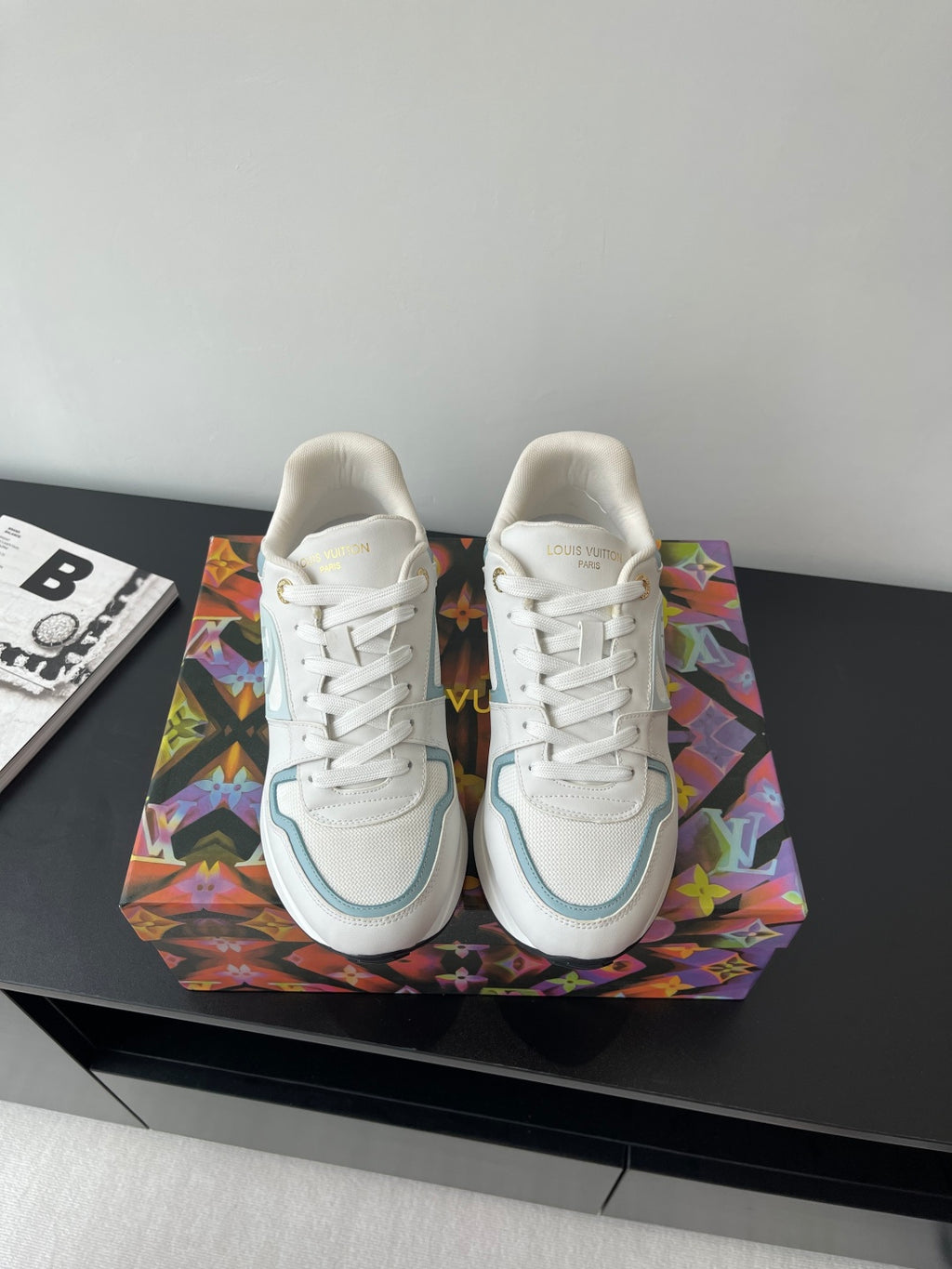 White and light blue lace-up sneakers with gold heel accents and side logo detail