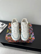 White and light blue lace-up sneakers with gold heel accents and side logo detail