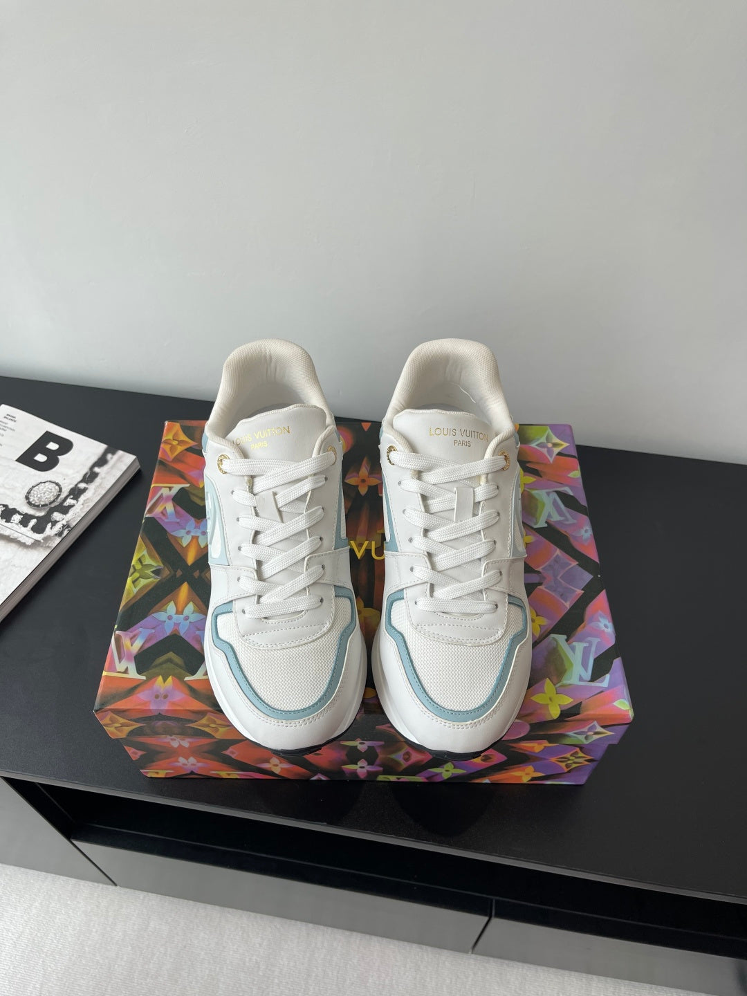 White and light blue lace-up sneakers with gold heel accents and side logo detail
