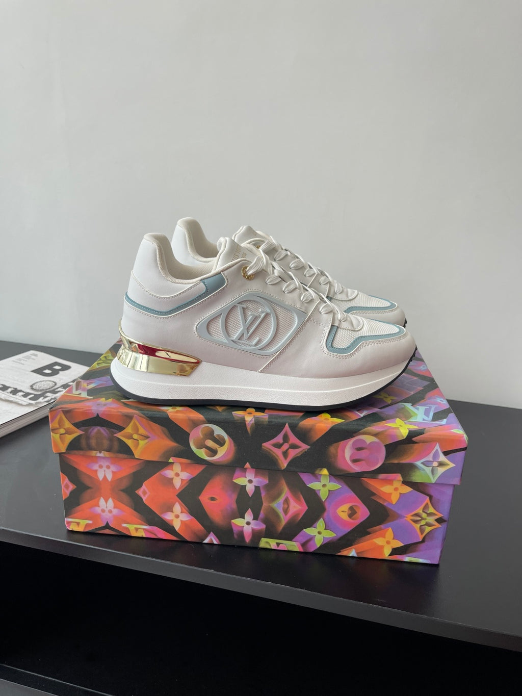 White and light blue lace-up sneakers with LV-style emblem on the side panel