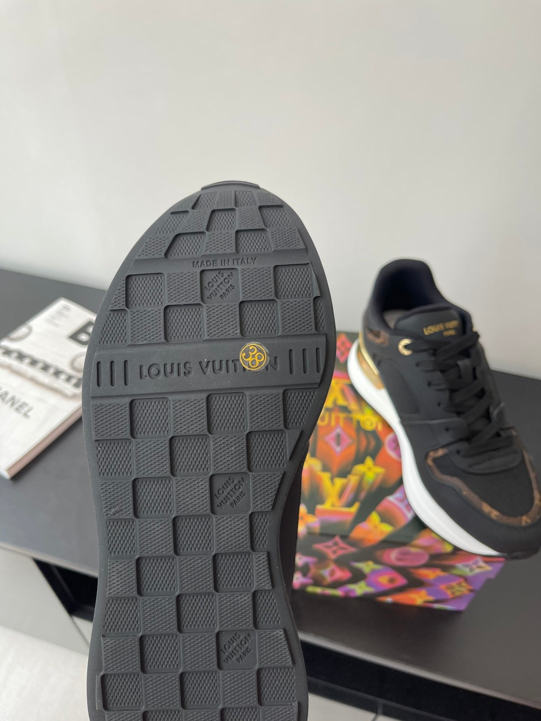 Ladies sneaker outsole, dark rubber tread with LV branding detail on heel.