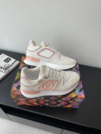 Louis Vuitton women's sneakers, angled view, white with pink emblem and colored midsole