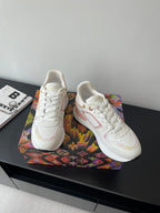 Louis Vuitton women's sneakers, angled pair, white upper with pink trim, laces visible