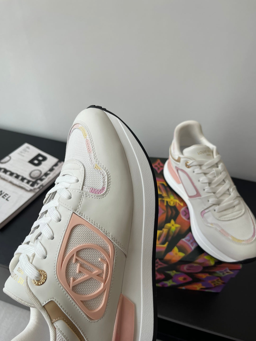 Louis Vuitton women's sneakers, side profile, white with pink emblem, lace-up design
