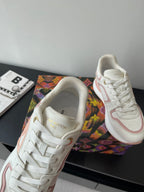 Women's Louis Vuitton sneakers close-up, white upper with pink piping and lace eyelets