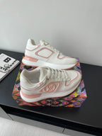 Women's Louis Vuitton sneakers angled view, white with pink logo patch on side