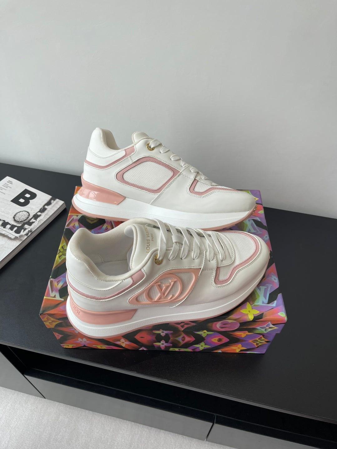 Women's Louis Vuitton sneakers angled view, white with pink logo patch on side