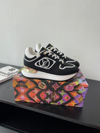 Ladies' Louis Vuitton sneakers on a colorful box, black uppers with white laces and trim.