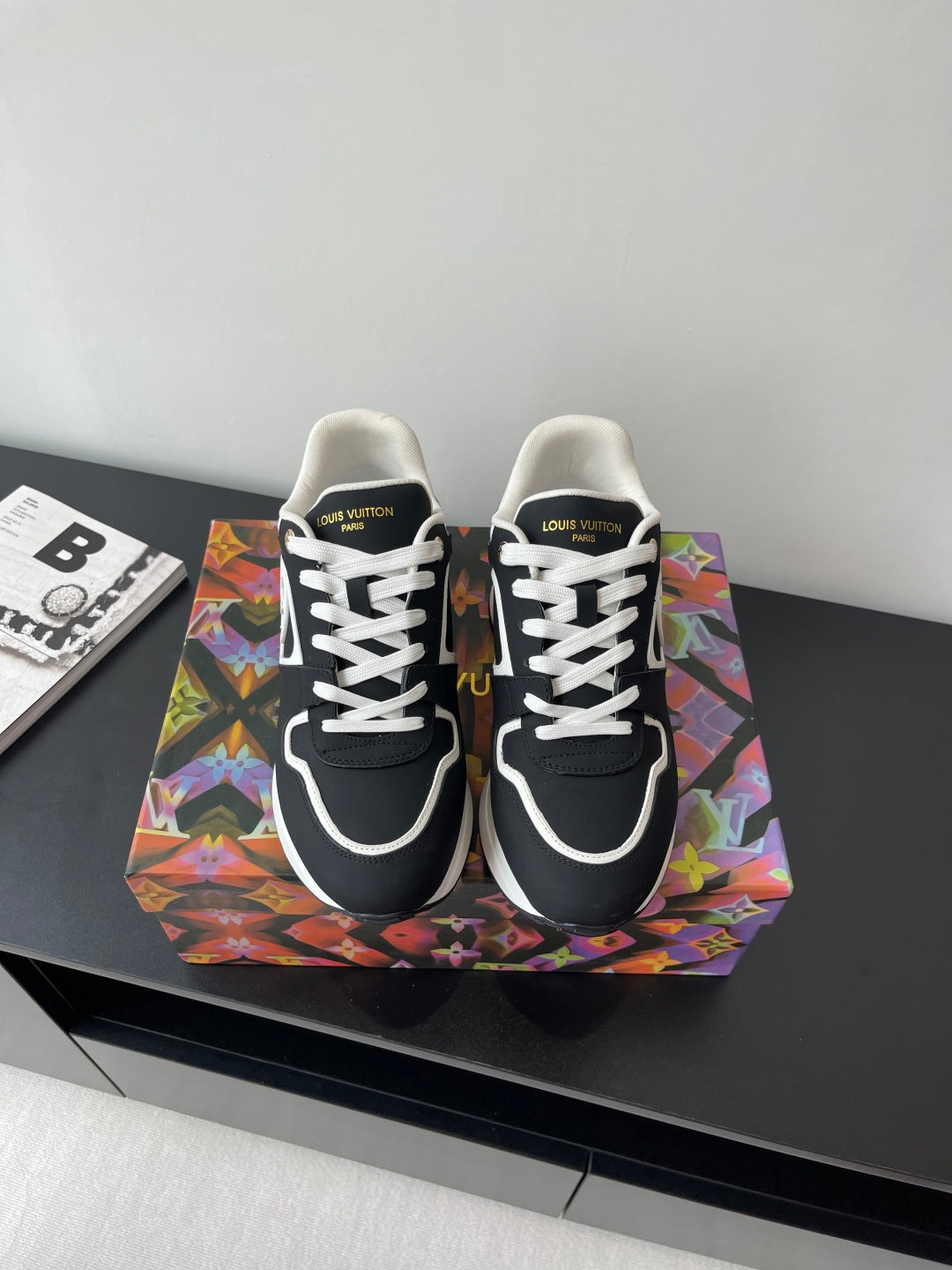 Ladies' Louis Vuitton sneakers, black with white laces and white logo trim, front view.