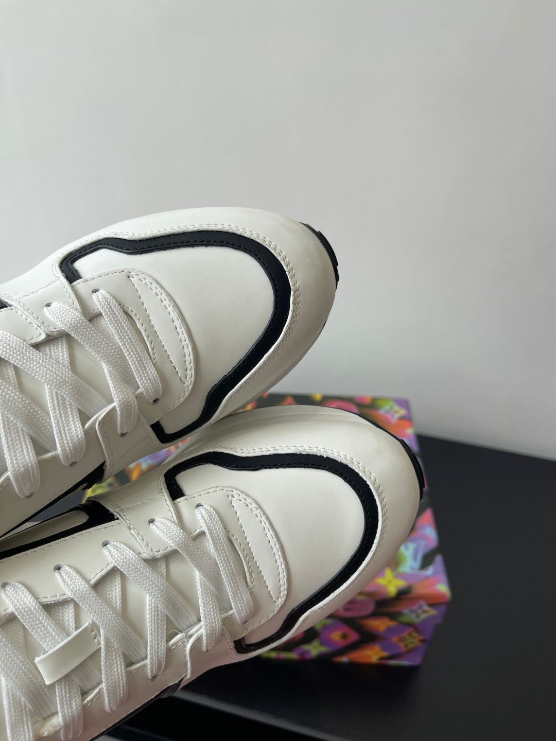 Close-up of white Louis Vuitton sneakers’ laces and black-trimmed collar