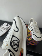 White Louis Vuitton sneakers with black trim and side emblem, on a box